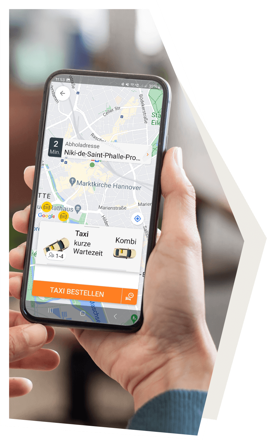 Eine Hand hält ein Smartphone mit der Darstellung der Taxi-App in der Anwendung.